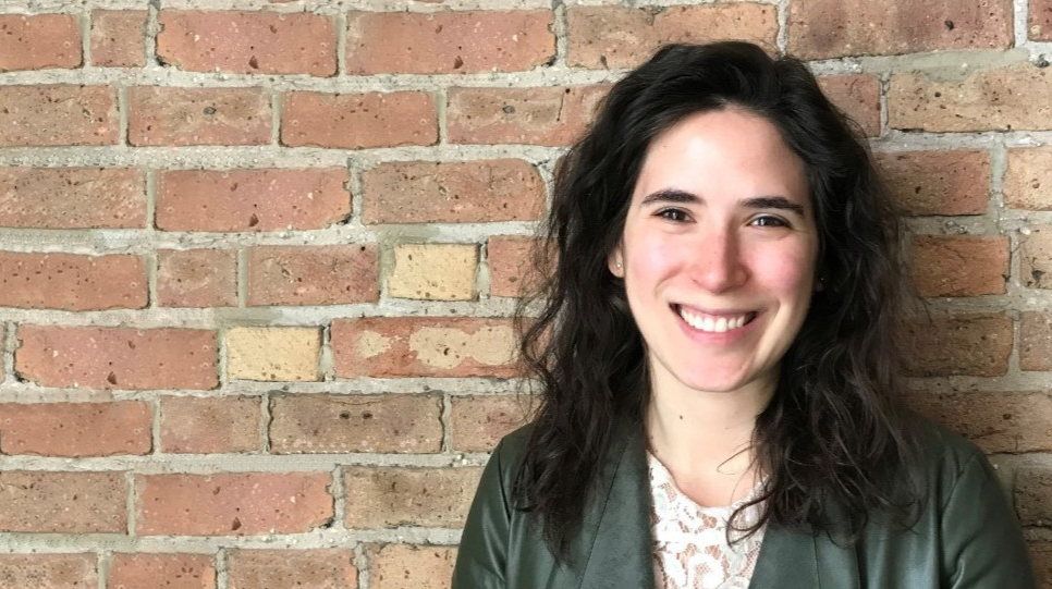 Business Data Analytics certificate student Hannah Becker smiling, leaning against a brick wall.